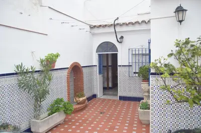 an internal courtyard of a building with potted plants at Downtown house centro histórico in Arcos de la Frontera