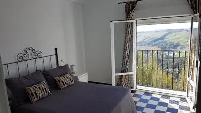 a bedroom with a bed and a balcony with a view at Apartamento centro histórico Arcos in Arcos de la Frontera