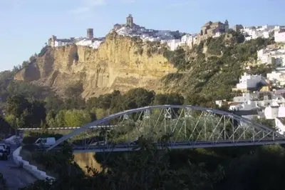 a bridge over a river in front of a mountain at Apartamento centro histórico Arcos in Arcos de la Frontera