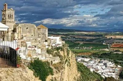 a castle on top of a mountain with a city at Apartamento centro histórico Arcos in Arcos de la Frontera