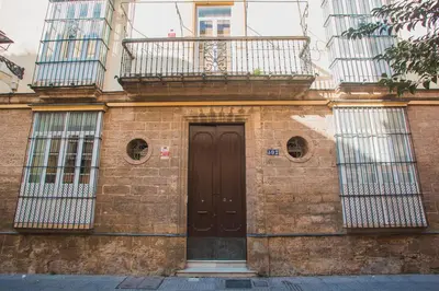 a brick building with a door and a balcony at Atico Cielos 102 in El Puerto de Santa María