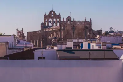 a large building with a church in the background at Atico Cielos 102 in El Puerto de Santa María