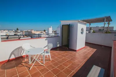 a patio with a table and chairs on a roof at Atico Cielos 102 in El Puerto de Santa María