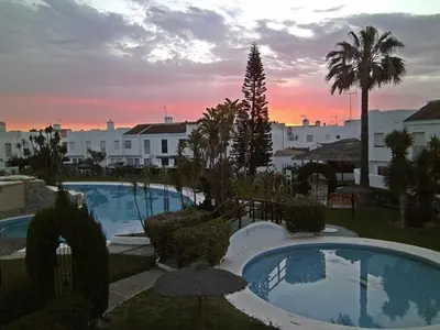 a view of two swimming pools in a resort at Precioso duplex con piscina en Real de la Barrosa in Chiclana de la Frontera