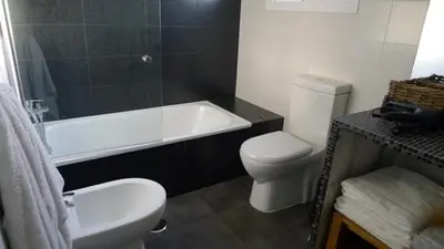 a bathroom with a tub and a toilet and a sink at Precioso duplex con piscina en Real de la Barrosa in Chiclana de la Frontera