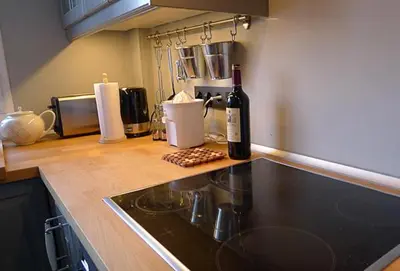 a bottle of wine sitting on top of a kitchen counter at Precioso duplex con piscina en Real de la Barrosa in Chiclana de la Frontera
