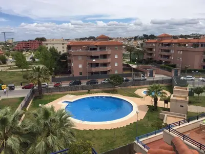 a large swimming pool in a city with buildings at Apartamento Julieta in Sanlúcar de Barrameda