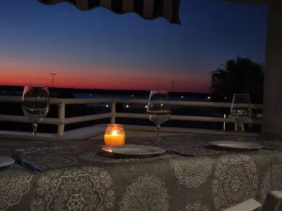 a table with three wine glasses and a candle on it at Avenida de las Piletas in Sanlúcar de Barrameda
