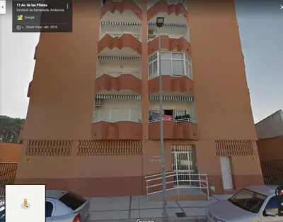 a building with cars parked in front of it at Avenida de las Piletas in Sanlúcar de Barrameda
