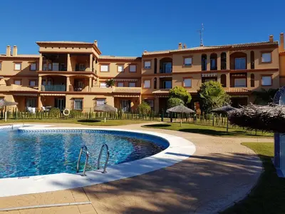 a building with a swimming pool in front of a building at Novo Paradise in Chiclana de la Frontera