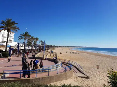 a group of people walking along a beach at Novo Paradise in Chiclana de la Frontera