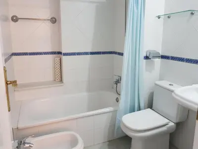a bathroom with a tub and a toilet and a sink at Novo Paradise in Chiclana de la Frontera