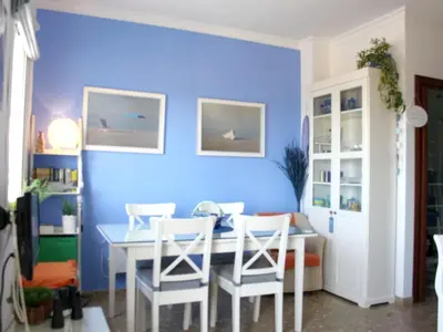 a dining room with a blue wall and a table and chairs at Cosy apartment with sea view in Chipiona - 50 m² in Chipiona