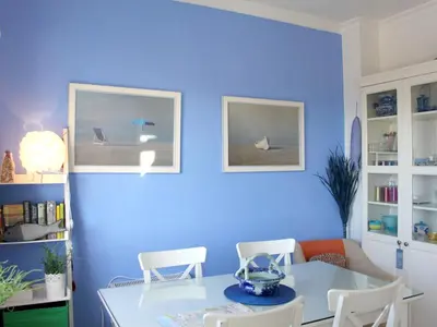 a blue room with a white table and chairs at Cosy apartment with sea view in Chipiona - 50 m² in Chipiona