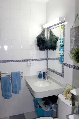 a bathroom with a sink and a mirror and a toilet at Cosy apartment with sea view in Chipiona - 50 m² in Chipiona