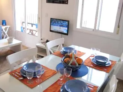 a dining room with a table with a bowl of fruit at Cosy apartment with sea view in Chipiona - 50 m² in Chipiona