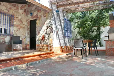 a patio with a table and chairs next to a building at Bungalow La Roa II in Conil de la Frontera