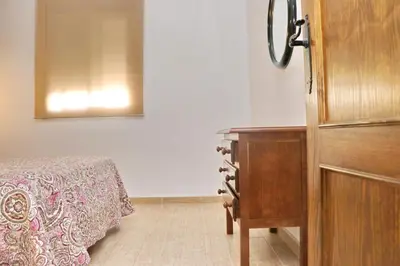 a bedroom with a bed and a wooden dresser at Bungalow La Roa II in Conil de la Frontera