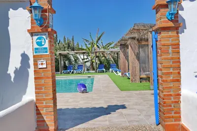 a bird is sitting next to a swimming pool at Bungalow La Roa II in Conil de la Frontera
