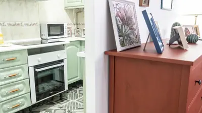 a kitchen with green cabinets and a microwave at El parador de la artesana in Cádiz