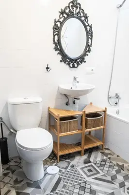a bathroom with a toilet and a sink and a mirror at El parador de la artesana in Cádiz