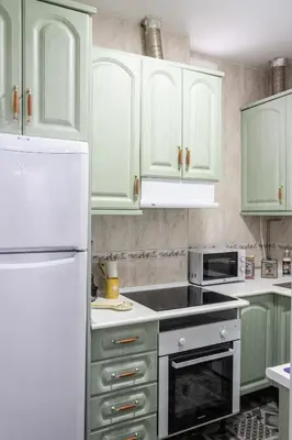 a kitchen with green cabinets and a white refrigerator at El parador de la artesana in Cádiz