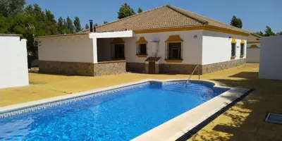 a villa with a swimming pool in front of a house at Alojamiento rural 