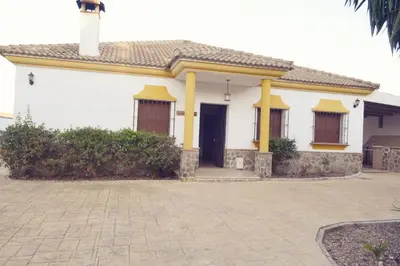 a white house with yellow columns and a door at Alojamiento rural 