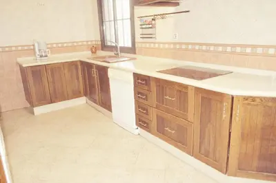 an empty kitchen with wooden cabinets and a sink at Alojamiento rural 