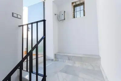 a staircase in a house with white walls and a window at Mi Bohemia Caleta in Cádiz