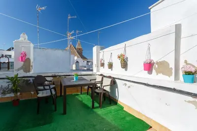a patio with a table and chairs on a balcony at Mi Bohemia Caleta in Cádiz