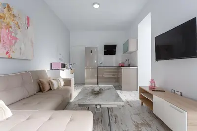a white living room with a couch and a table at Mi Bohemia Caleta in Cádiz