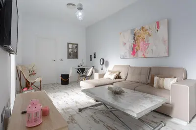 a white living room with a couch and a table at Mi Bohemia Caleta in Cádiz