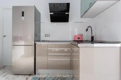 a kitchen with white cabinets and a refrigerator at Mi Bohemia Caleta in Cádiz