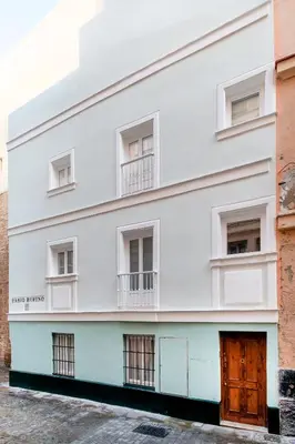 a white building with windows and a door at Casa La Muralla MEDIEVAL by Cadiz4Rentals in Cádiz