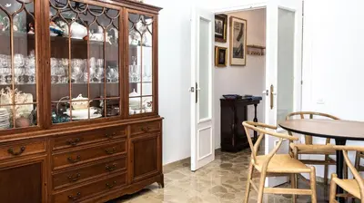 a dining room with a wooden hutch and a table at Apartamento Cadiz Paradiso in Cádiz