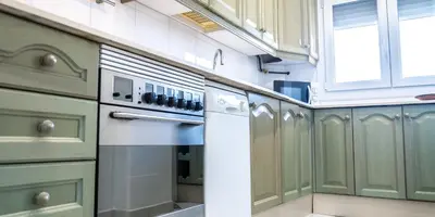 a kitchen with green cabinets and a white refrigerator at Apartamento Cadiz Paradiso in Cádiz