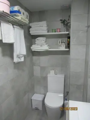 a bathroom with a white toilet and some towels at Apartamento La Gaviota in Chipiona