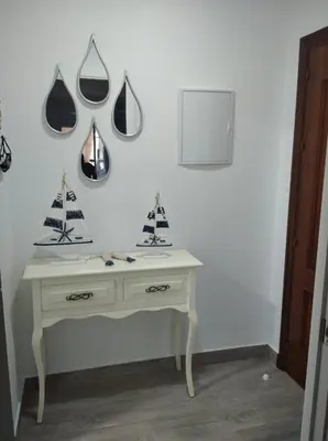 a white room with a table with two sails on the wall at Apartamento La Gaviota in Chipiona