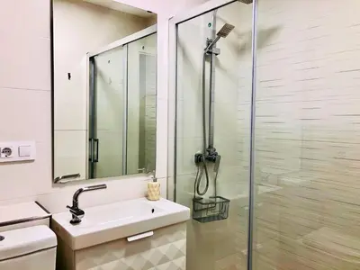 a white bathroom with a shower and a sink at Apartamento Ecuador in Cádiz