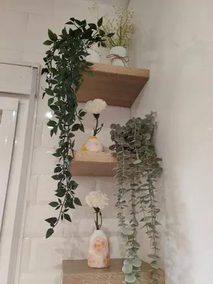 a shelf with flowers and vases on it at Villa Solea in Chiclana de la Frontera