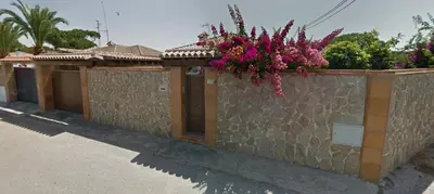a stone wall with flowers on top of it at Villa Solea in Chiclana de la Frontera