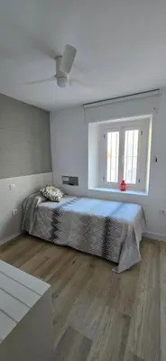 a bedroom with a large bed and a window at Apartamento Arbolí in Cádiz