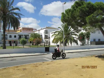 a person riding a motorcycle down a street at CALLE YERBABUENA 5 in Sanlúcar de Barrameda