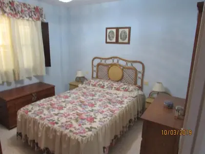 a bedroom with a bed with a floral bedspread at CALLE YERBABUENA 5 in Sanlúcar de Barrameda