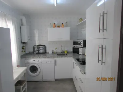 a white kitchen with a washing machine and a washer at CALLE YERBABUENA 5 in Sanlúcar de Barrameda
