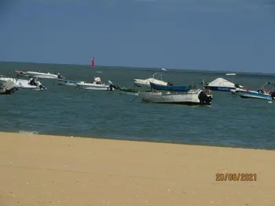 a group of boats in the water near a beach at CALLE YERBABUENA 5 in Sanlúcar de Barrameda