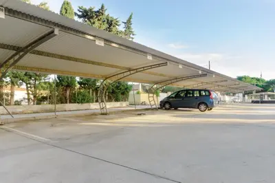 a parking lot with a car parked under awning at Pinar 12 in Chiclana de la Frontera