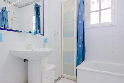 a white bathroom with a sink and a shower at Pinar 12 in Chiclana de la Frontera