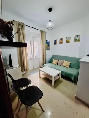 a living room with a green couch and a table at Apartamento Feduchy in Cádiz